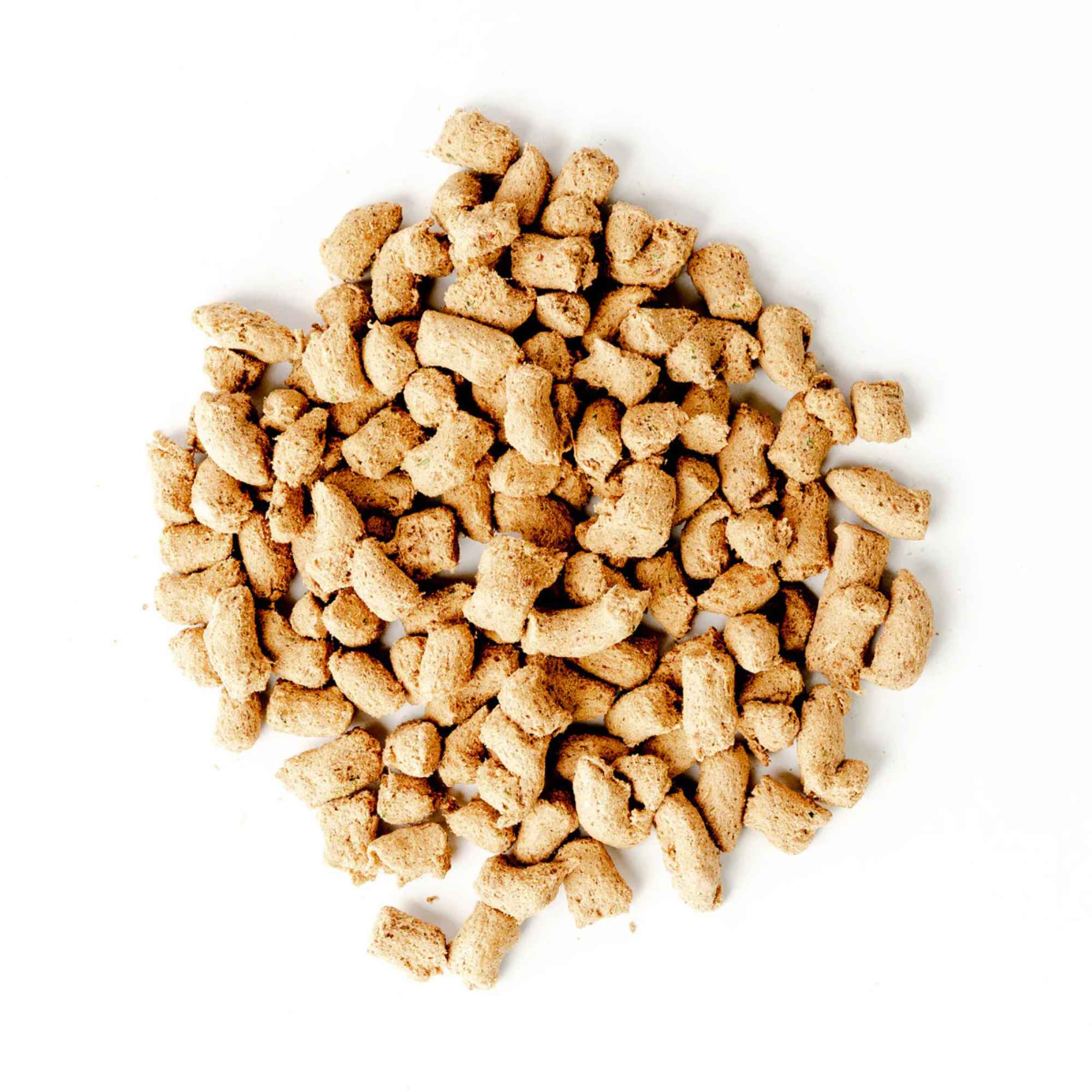 Pile of green juju chicken and sardine food pieces on a white background