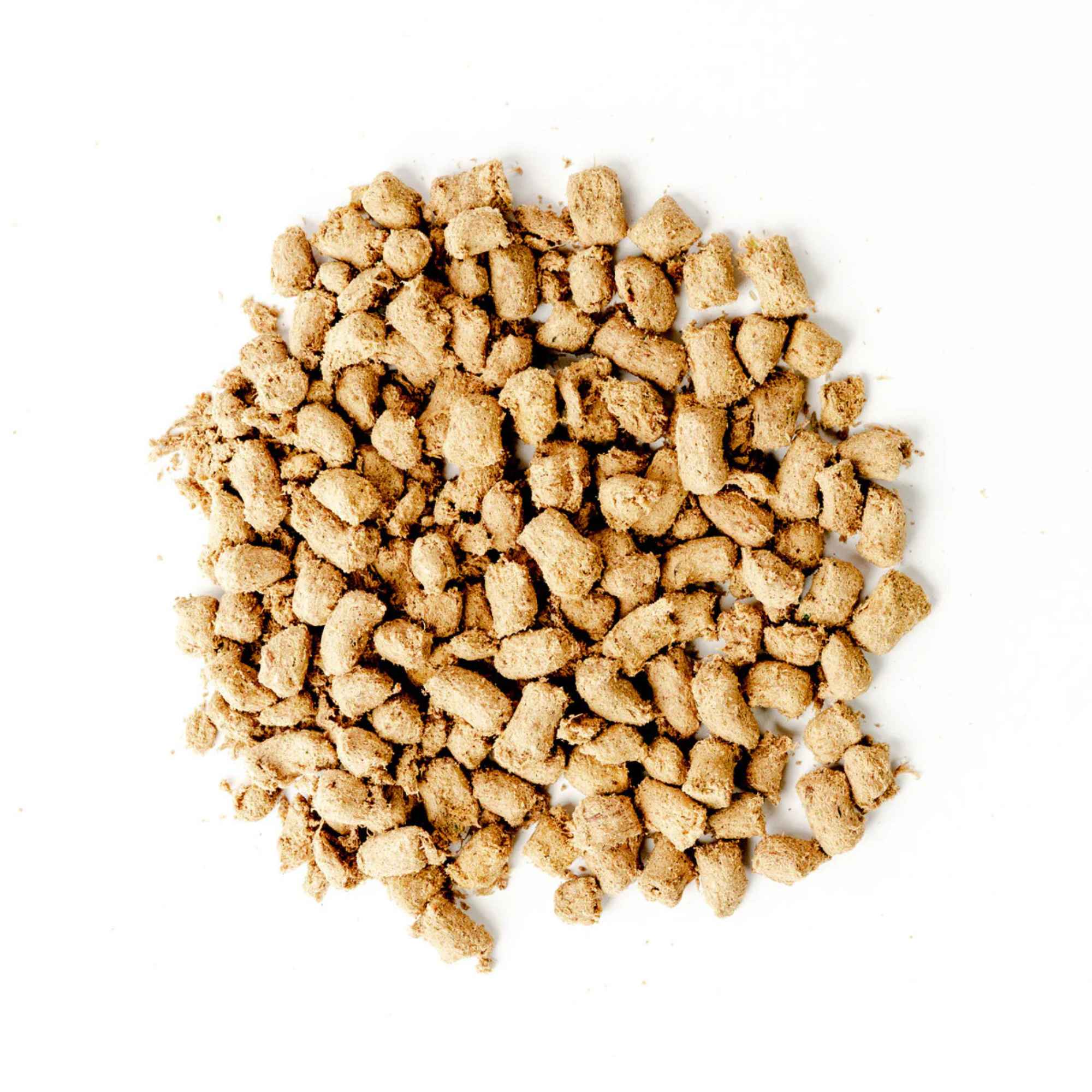 Pile of green juju duck and sardines freeze dried raw food pieces on a white background