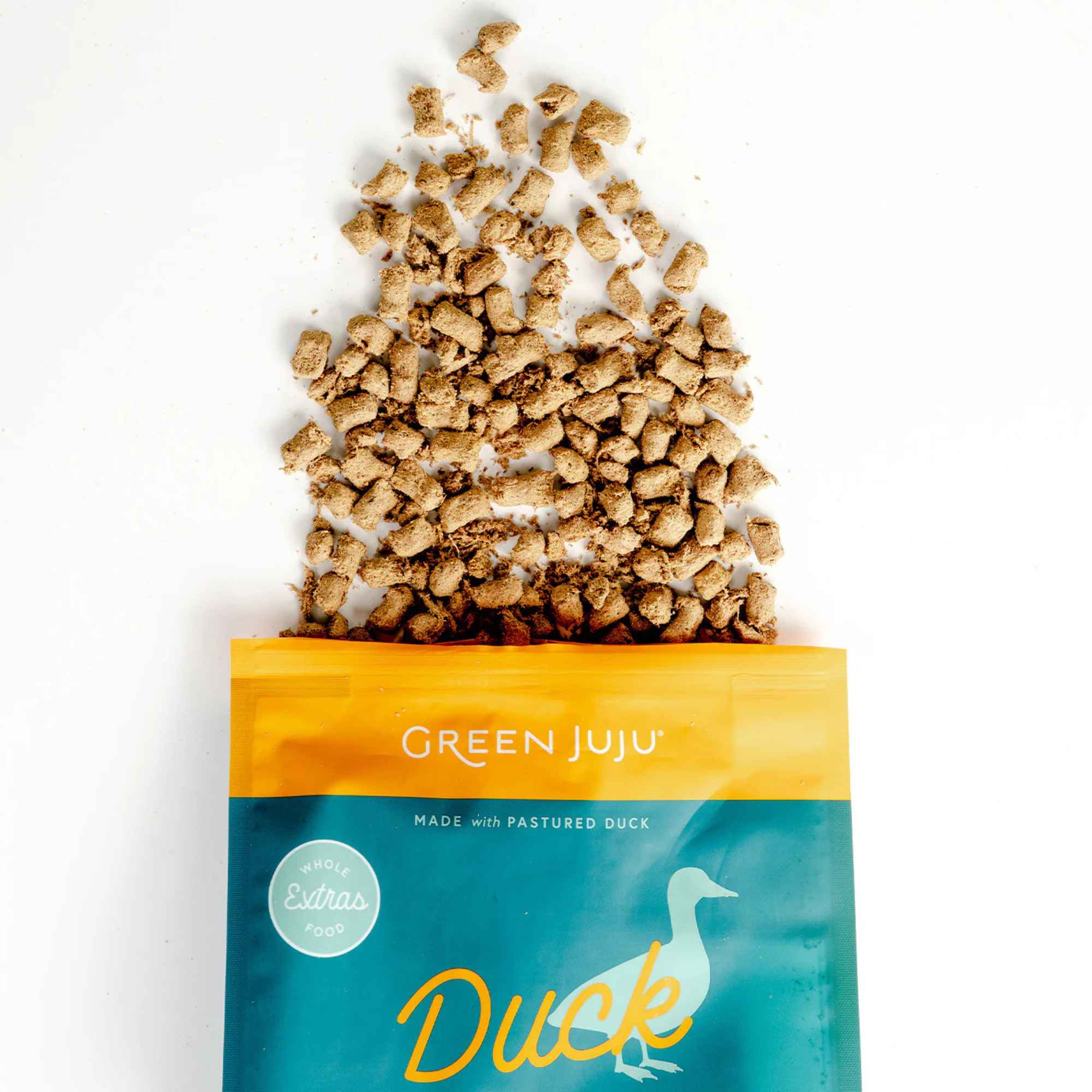 Green Juju freeze dried raw duck and sardine food packaging with spilled product on a white background