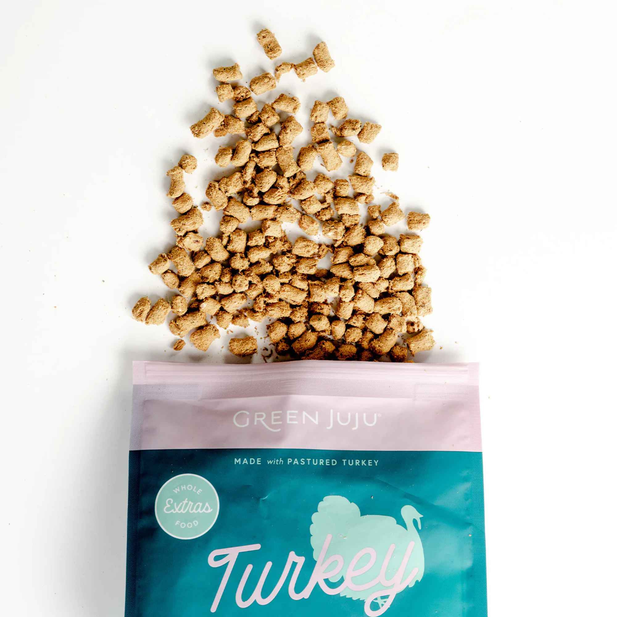 Green Juju turkey and sardine freeze dried raw food packaging with spilled food on a white background